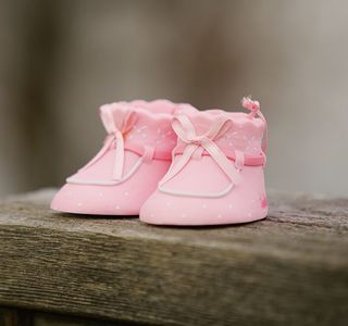 selective focus photography of pink shoes on wooden bench