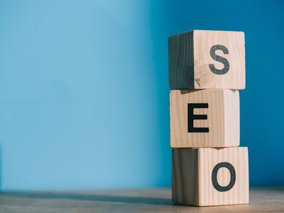SEO word made from wooden alphabet cubes on blue background