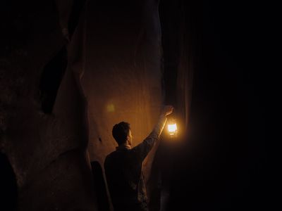 a man holding a lantern in the dark