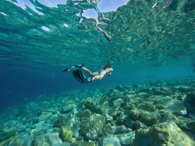 Croatia, Girl (10-11) snorkeling, rear view