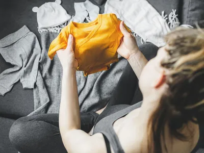 Jeune femme préparant des vêtements pour le bébé