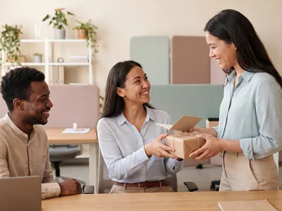 Collègues de bureau remettant un cadeau à un collègue pour une naissance ou une adoption