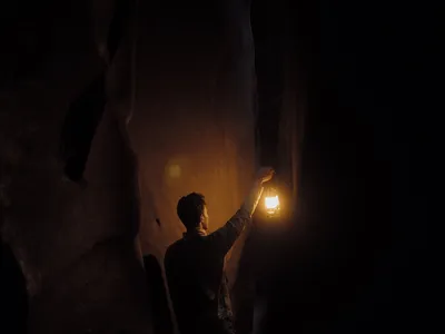 a man holding a lantern in the dark