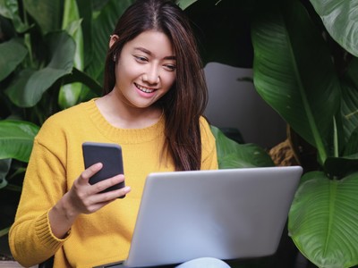 asian woman excited with sale promotion on website shop on laptop