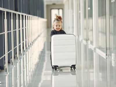 Petite fille avec une valise dans un couloir d'aéroport