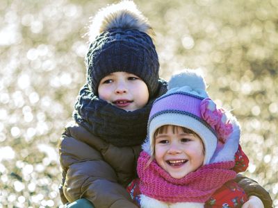 deux enfants heureux, emmitouflés dans leurs bonnets et écharpes