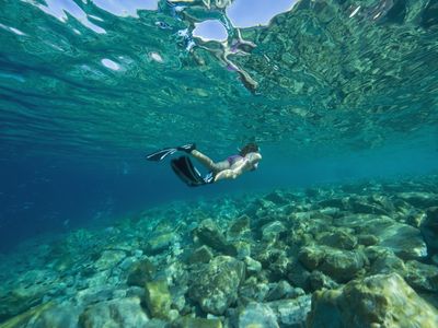 Croatia, Girl (10-11) snorkeling, rear view