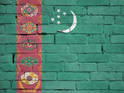 Turkmenistan flag is painted onto an old brick wall