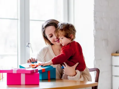 Une maman aide son fils à ouvrir des cadeaux