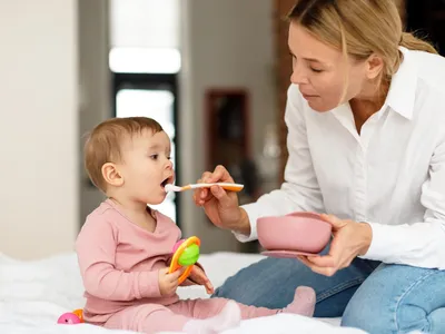 Une femme nourrit un jeune enfant ÃÂ  la cuillÃÂ¨re