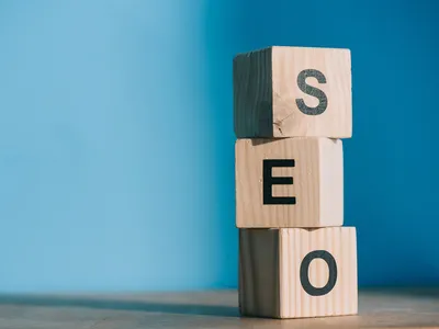 SEO word made from wooden alphabet cubes on blue background