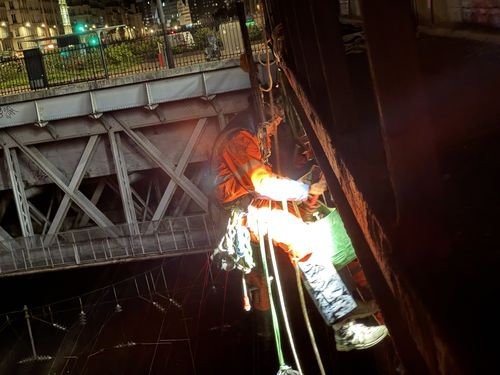 Cordiste UNICORDE suspendu sur corde contre une poutre mÃÂ©tallique, Paris 17