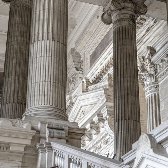 a building with columns and a clock on the side of it