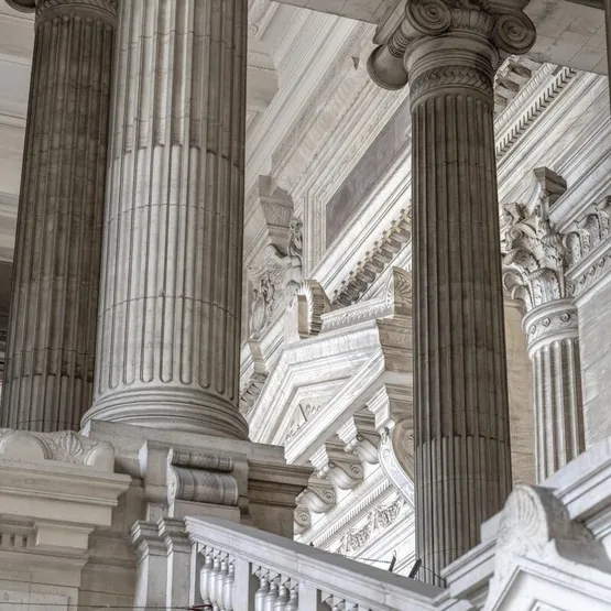 a building with columns and a clock on the side of it