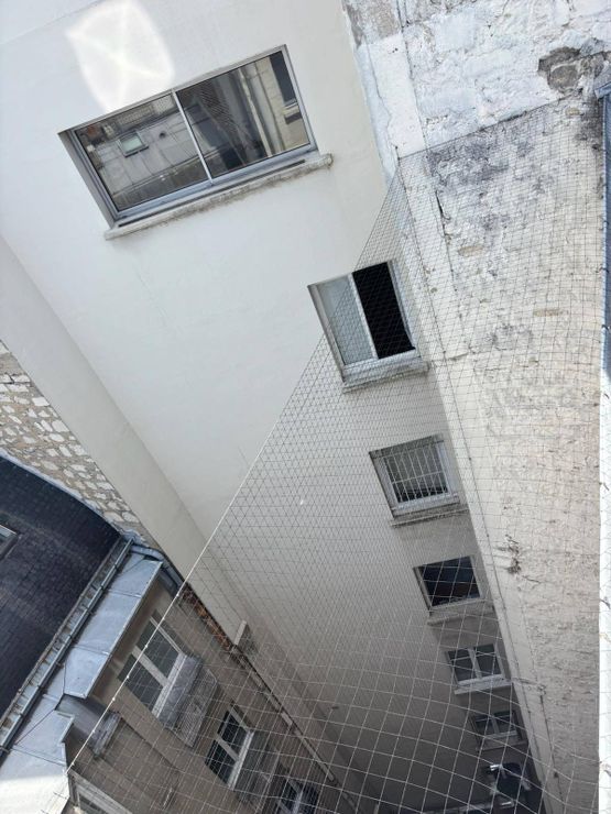 DÃÂ©tail de la pose d'un filet anti-volatile en hauteur