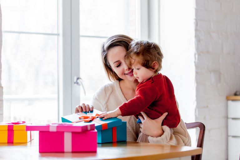 Une maman aide son fils à ouvrir des cadeaux